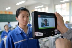 Nauczyciel posługuje się maszyną wykorzystującą technologię rozpoznawania twarzy oraz linii papilarnych do sprawdzenia tożsamości uczniów przed próbnym egzaminem wstępnym do szkoły w mieście Handan, w prowincji Hebei. Chiny, 6.06.2017 r. (STR/AFP/Getty Images)