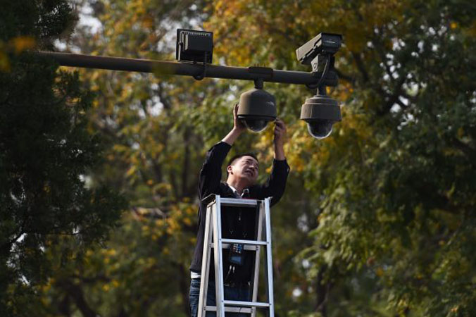 Pracownik dostraja kamerę bezpieczeństwa na pl. Tiananmen w Pekinie, 30.08.2014 r. (Greg Barker/AFP/Getty Images)