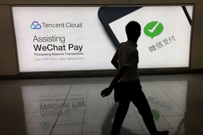 Mężczyzna przechodzi obok reklamy platformy społecznościowej WeChat na międzynarodowym lotnisku w Hongkongu, 21.08.2017 r. (Richard A. Brooks/AFP/Getty Images)