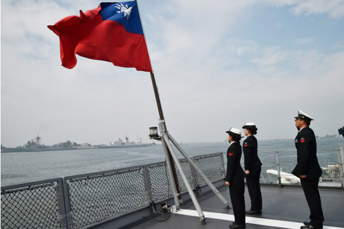 Tajwańscy marynarze salutują fladze narodowej na pokładzie okrętu zaopatrzeniowego Panshih w bazie marynarki wojennej w Kaohsiung 31.01.2018 r. (Mandy Cheng/AFP/Getty Images)