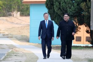 Przywódca Korei Północnej Kim Dzong Un (po prawej) rozmawia z prezydentem Korei Południowej Mun Dze Inem (po lewej) w strefie zdemilitaryzowanej w wiosce przygranicznej Panmundżom w Korei Południowej, 27.04.2018 r. (KOREA SUMMIT PRESS/PAP/EPA)