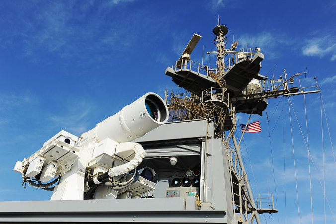 USS Ponce (AFSB(I)-15), okręt desantowy należący do marynarki wojennej USA, przebywający w Zatoce Perskiej, przeprowadza pokaz działania Systemu Broni Laserowej (LaWS – Laser Weapon System), na którą środki przeznaczyło Biuro Badań Marynarki Wojennej (ONR – Office of Naval Research) (By Office of Naval Research from Arlington, United States – 141116-N-PO203-042, CC BY 2.0 / Wikimedia, https://commons.wikimedia.org/w/index.php?curid=64234994)