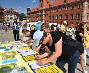 Przechodnie na pl. Zamkowym w Warszawie podpisują petycję do Wysokiego Komisarza ONZ ds. Praw Człowieka przeciwko grabieży organów w Chinach, 13.05.2018 r. (The Epoch Times)