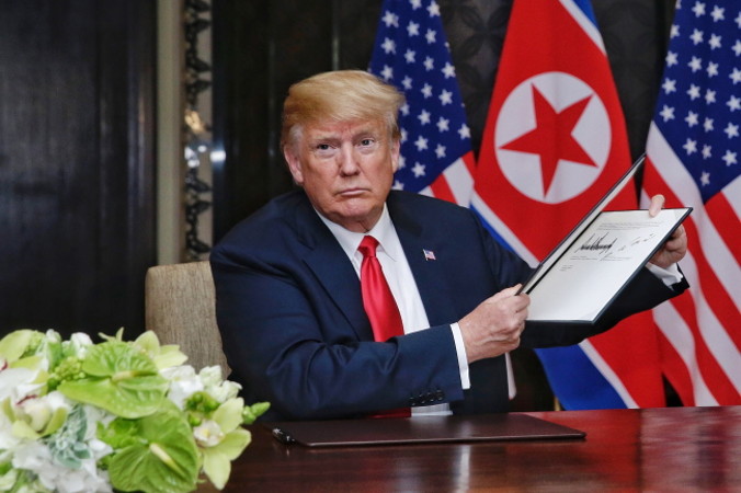 Prezydent USA Donald J. Trump prezentuje dokument, który właśnie podpisał podczas historycznego szczytu Korea Północna – Stany Zjednoczone, hotel Capella na wyspie Sentosa w Singapurze, 12.06.2018 r. (KEVIN LIM / THE STRAITS TIMES / SPH/PAP/EPA)
