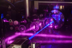 Zdjęcie ilustracyjne przedstawia zegar atomowy JILA 2 składający się m.in. z siatki utworzonej przez trzy pary wiązek laserowych (National Institute of Standards and Technology / <a href="https://commons.wikimedia.org/w/index.php?curid=67815679">domena publiczna</a>)