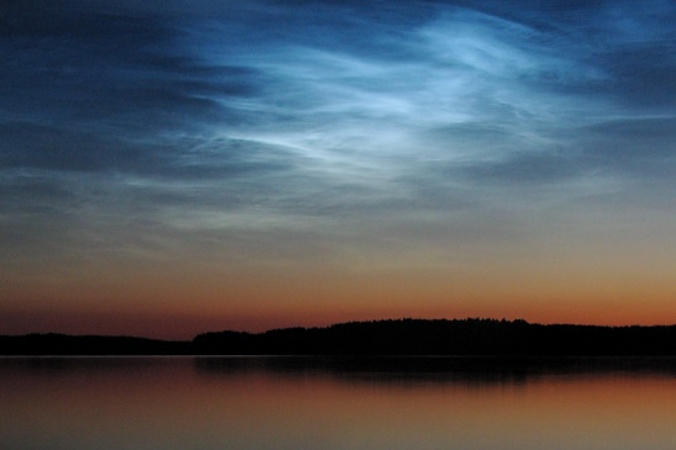 Obłoki srebrzyste, ang. noctilucent clouds, NLC, nad jeziorem Saimaa w Finlandii (Mika Yrjölä – English Wikipedia, Noctilucent clouds by Explo on Flickr, CC BY 2.0 / <a href="https://commons.wikimedia.org/w/index.php?curid=218856">Wikimedia</a>)