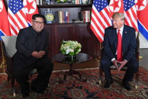 Przywódca Korei Płn. Kim Dzong Un śmieje się wraz z prezydentem Donaldem Trumpem w trakcie rozmów na szczycie USA – Korea Płn. w hotelu Capella, na wyspie Sentosa, Singapur, 12.06.2018 r. (SAUL LOEB/AFP/Getty Images)