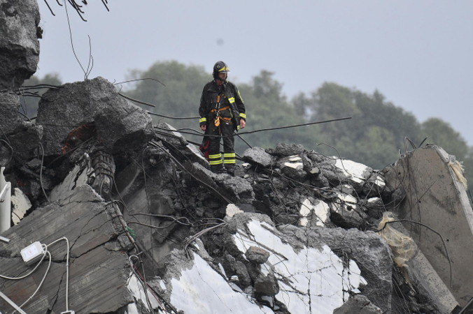 Ratownik na gruzach wiaduktu na autostradzie w Genui, Włochy, 14.08.2018 r. (LUCA ZENNARO/PAP/EPA)