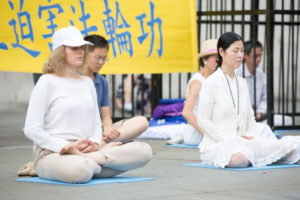 Praktykujący Falun Gong medytują na londyńskim Trafalgar Square (Max Lin / The Epoch Times)