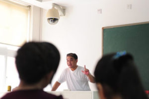 Kamera monitoringu zamontowana nad podium wykładowcy podczas wykładu profesora uniwersyteckiego Ilhama Tohti w sali wykładowej w Pekinie, Chiny, 12.06.2010 r. (Frederic J. Brown/AFP/Getty Images)