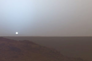 Niemal cała północna półkula Marsa to ogromna nizina, położona ponad sześć kilometrów poniżej średniej wysokości terenu dla południowej półkuli tej planety. Na zdjęciu zachód Słońca na Marsie uwieczniony przez łazik Spirit z krateru Gusiewa, 19.05.2005 r. (NASA – NASA's Mars Exploration Rover: Spirit [1] / <a href="https://commons.wikimedia.org/w/index.php?curid=358121">domena publiczna</a>)