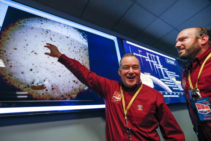 Tom Hoffman (po lewej), kierownik projektu InSight, NASA JPL wskazuje na pierwszy obraz z lądownika Mars InSight wkrótce po potwierdzeniu udanego lądowania na powierzchni Marsa, Mission Support Area w NASA Jet Propulsion Laboratory, Pasadena w Kalifornii, USA, 26.11.2018 r. (AL SEIB/PAP/EPA)
