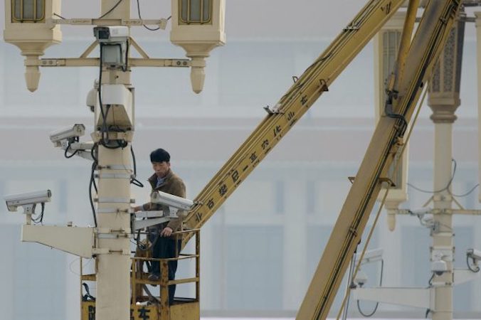 Mężczyzna sprawdza kamery monitoringu na placu Tiananmen w Pekinie, 31.10.2013 r. (Ed Jones/AFP/Getty Images)