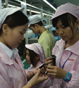 Chińskie pracownice oglądają tańszą, lokalną, alternatywę do zegarków Apple Watch, Shenzhen, południowa prowincja Chin, Guangdong, 22.04.2015 r. (STR/AFP/Getty Images)