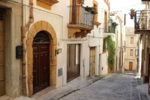 Domy wystawione na sprzedaż w Sambuca di Sicilia usytuowane są w centrum miejscowości. Na zdjęciu uliczka w miasteczku na Sycylii, dokładniejsza lokalizacja nieoznaczona (Samueles / <a href="https://pixabay.com/pl/sicily-krajobraz-w%C5%82ochy-lato-1814598/">Pixabay</a>)