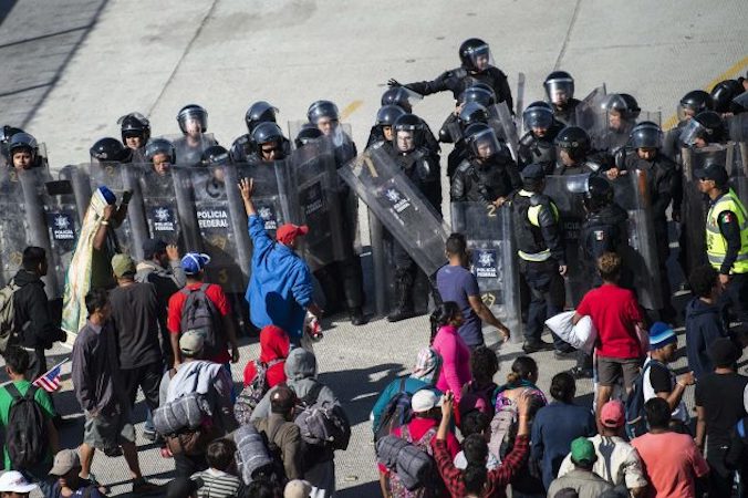 Imigranci z Ameryki Środkowej po dotarciu do przejścia granicznego El Chaparral w Tijuanie, zostali zablokowani przez meksykańskie siły policyjne, Meksyk, 25.11.2018 r. (Pedro Pardo/AFP/Getty Images)