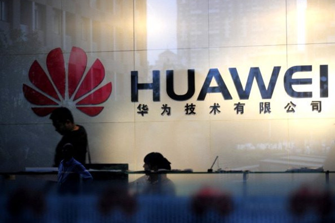 Personel i goście przechodzą przez lobby w biurze Huawei w Wuhan, w prowincji Hubei w centralnych Chinach, 8.10.2012 r. (STR/AFP/GettyImages)