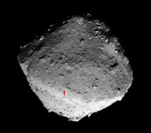 Zdjęcie zrobione przez sondę Hayabusa 2 w dniu 24.01.2019 r., dostarczone przez Japońską Agencję Badań Kosmicznych (JAXA), pokazuje miejsce lądowania (czerwona strzałka) sondy kosmicznej Hayabusa 2 na asteroidzie Ryugu. Wydane 22.02.2019 r. (JAXA/HANDOUT/PAP/EPA)