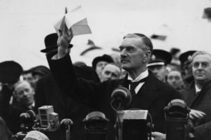Brytyjski polityk i premier Neville Chamberlain (1869-1940) po powrocie z Monachium, gdzie wziął udział w spotkaniu z Hitlerem, oznajmił w swym orędziu: „przywiozłem wam pokój na nasze czasy”, lotnisko w Heston, położone na zachód od Londynu, 30.09.1938 r. (Central Press / Getty Images)