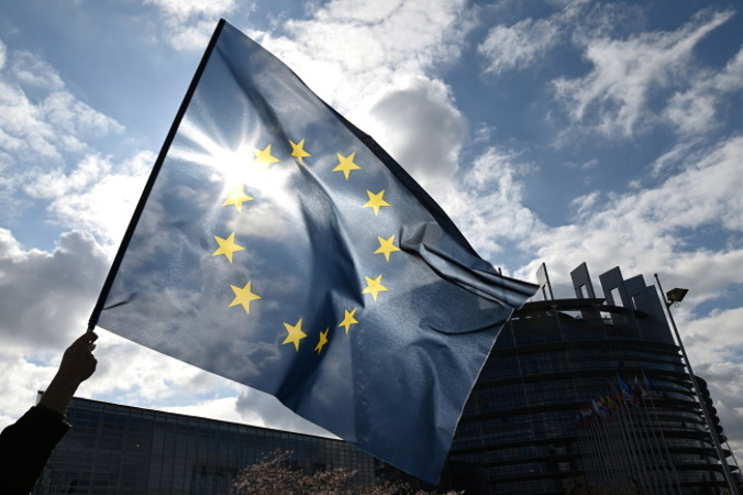 Demonstrant trzyma flagę europejską podczas protestu przed Parlamentem Europejskim. Debata w PE dotyczyła dyrektywy o prawach autorskich, Strasburg, Francja, 26.03.2019 r. (PATRICK SEEGER/PAP/EPA)