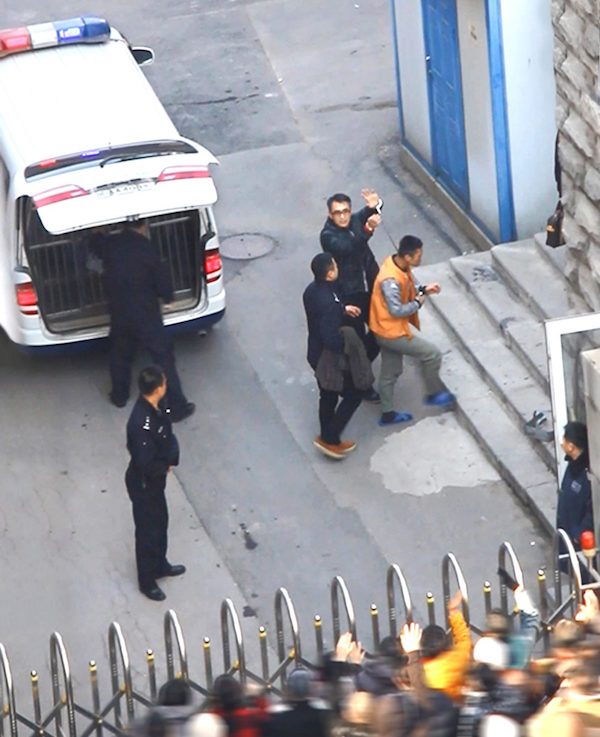 Yu Ming podnosi ręce zakute w kajdanki. Został przywieziony na rozprawę sądową w mieście Shenyang, 20.11.2014 r. (Mingui.org)