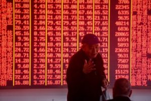 Inwestorzy rozmawiają, stojąc przed elektroniczną tablicą, na której wyświetlają się informacje o akcjach holdingu z Hangzhou we wschodniej prowincji Zhejiang w Chinach, 3.12.2018 r. (STR/AFP/Getty Images)