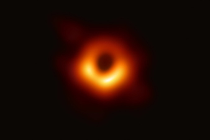 Niedatowana fotografia z materiałów prasowych udostępniona przez Event Horizon Telescope Collaboration w dniu 10.04.2019 r., przedstawiająca jasny pierścień uformowany, gdy światło zakrzywia się na skutek ogromnej grawitacji wokół czarnej dziury, 6,5 mld razy masywniejszej niż Słońce. Naukowcy uzyskali pierwszy obraz czarnej dziury, wykorzystując obserwacje teleskopu Event Horizon w centrum galaktyki M87 (EVENT HORIZON TELESCOPE COLLABORATION/HANDOUT/PAP/EPA)