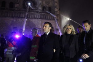 Prezydent Francji Emmanuel Macron (pośrodku) i jego żona Brigitte Macron odwiedzają strażaków walczących z ogniem trawiącym dach katedry Notre Dame w Paryżu, 15.04.2019 r. (YOAN VALAT/PAP/EPA)