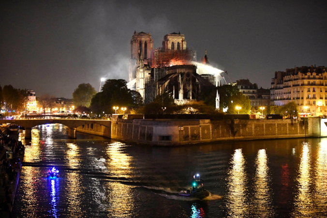 Francuscy strażacy gaszą płonący dach katedry Notre Dame w Paryżu, Francja, 15.04.2019 r. (JULIEN DE ROSA/PAP/EPA)