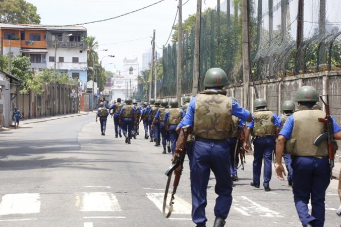 Uzbrojeni policjanci patrolują teren po wybuchu w kościele św. Antoniego w Kochchikade w Kolombo na Sri Lance, 21.04.2019 r. (M.A. PUSHPA KUMARA/PAP/EPA)