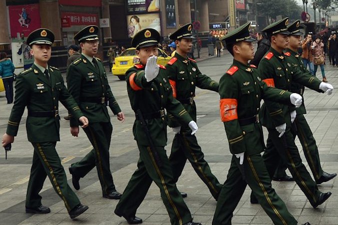 Chińska policja paramilitarna maszeruje przez śródmiejską dzielnicę handlową Chongqing (Mark Ralston/AFP/Getty Images)