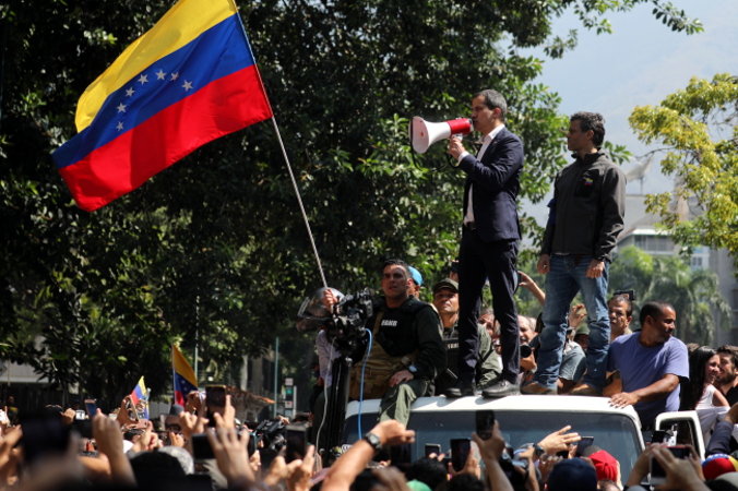 Przewodniczący Zgromadzenia Narodowego Wenezueli Juan Guaidó (pośrodku, z megafonem) i wenezuelski lider opozycji Leopoldo López (po prawej) przemawiają podczas protestu w Caracas w Wenezueli, 30.04.2019 r. (Miguel Gutierrez/PAP/EPA)