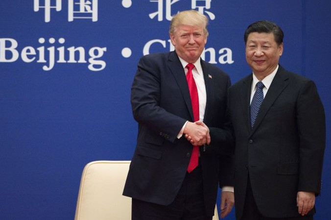 Prezydent Stanów Zjednoczonych Donald Trump i chiński przywódca Xi Jinping podają sobie ręce podczas spotkania liderów biznesu w Wielkiej Hali Ludowej w Pekinie, 9.11.2017 r. (NICOLAS ASFOURI/AFP/Getty Images)