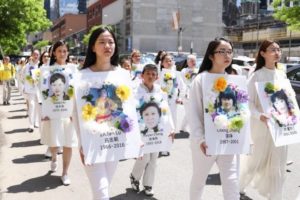 Praktykujący Falun Dafa podczas parady z okazji Światowego Dnia Falun Dafa w Nowym Jorku niosą plakaty z wizerunkami ofiar, które zmarły w Chinach na skutek prześladowań, 16.05.2019 r. (Samira Bouaou / The Epoch Times)