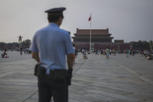 Chiński policjant podczas patrolu przygląda się turystom zbierającym się na placu Tiananmen w Pekinie w 27. rocznicę stłumienia protestów prodemokratycznych 4 czerwca 1989 r., Pekin, 4.06.2016 r.<br/>(Fred Dufour/AFP/Getty Images)