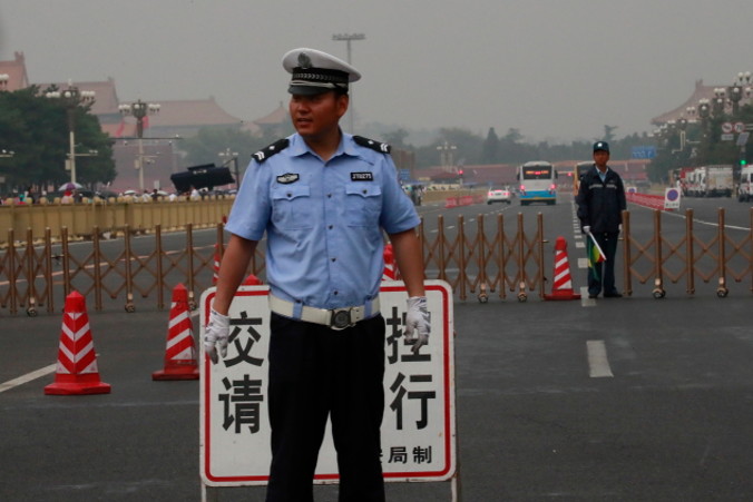 Funkcjonariusze policji stoją na straży obok barierek u wylotu drogi prowadzącej wzdłuż wschodniej części placu Tiananmen w 30. rocznicę protestów na placu Tiananmen w 1989 roku w Pekinie, Chiny, 4.06.2019 r. (HOWEE YOUNG/PAP/EPA)