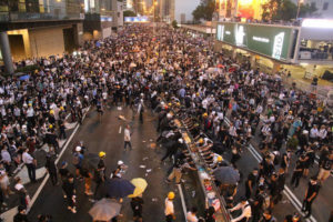 Protestujący wycofali się na ulicę w pobliżu Centrum Finansowego Dalekiego Wschodu w Hongkongu, po tym jak policja wystrzeliła gaz łzawiący i gaz pieprzowy, aby rozproszyć tłum (Dennis Law / The Epoch Times)