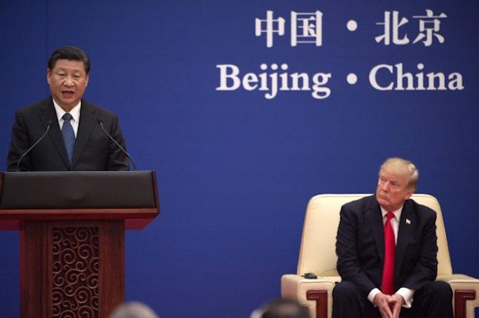 Przywódca Komunistycznej Partii Chin Xi Jinping (po lewej) przemawia obok siedzącego nieopodal prezydenta Donalda Trumpa podczas spotkania liderów biznesu w Wielkiej Hali Ludowej w Pekinie, 9.11.2017 r.<br/>(NICOLAS ASFOURI/AFP/Getty Images)