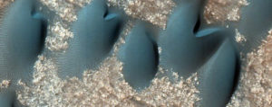 Wydmy na dnie krateru w marsjańskim regionie Terra Cimmeria, widziane przez HiRISE w programie HiWish. Większość z nich to wydmy sierpowate – barchany (<a href="https://hirise.lpl.arizona.edu/ESP_023561_1410">Jim Secosky zmodyfikował zdjęcie NASA</a> / <a href="https://commons.wikimedia.org/w/index.php?curid=38715253">domena publiczna</a>)