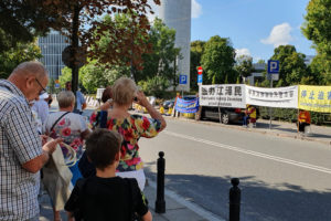 Przechodnie obserwują cichy apel praktykujących Falun Dafa w przededniu 20. rocznicy rozpoczęcia prześladowań tej duchowej dyscypliny przez KPCh, Warszawa, przed Kancelarią Sejmu RP, 18.07.2019 r. (Alina Zhang / The Epoch Times)