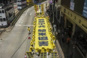 Zwolennicy duchowej praktyki Falun Gong w trakcie marszu nawołują do sprzeciwu wobec prześladowań Falun Gong w Chinach, Hongkong, 21.07.21019 r. Hasło na podłużnym transparencie wzywa do zakończenia prześladowań Falun Gong, które zapoczątkowała<br/>Komunistyczna Partia Chin w 1999 r. (Yu Kong / The Epoch Times)