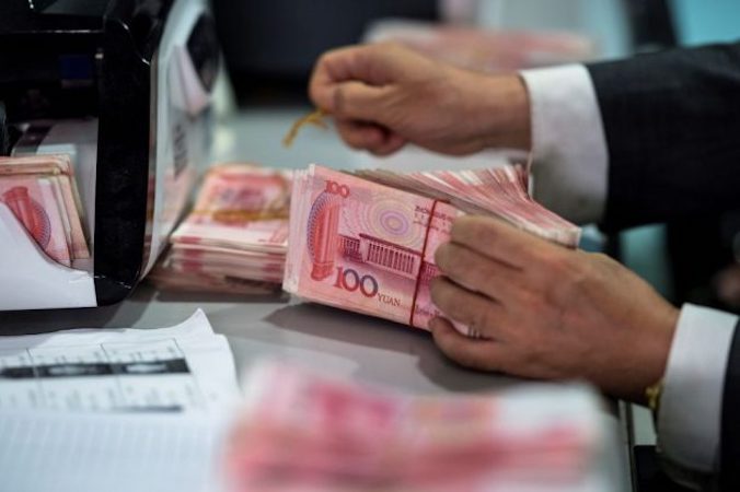 Pracownik banku odlicza plik banknotów 100-juanowych (14,3 USD) w banku w Szanghaju, 8.08.2018 r. (JOHANNES EISELE/AFP/Getty Images)