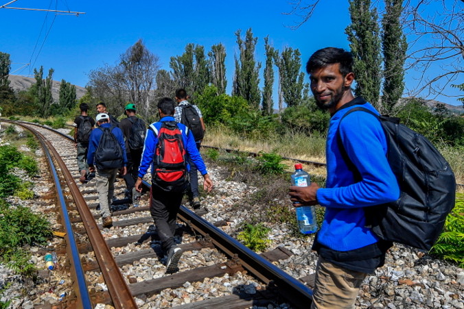 Grupa nielegalnych imigrantów z Pakistanu idzie wzdłuż torów kolejowych obok miasta Wełes w Macedonii Północnej, 14.08.2019 r. Według relacji podróżują od granicy Grecji z Macedonią Północną do miasta Wełes (ok. 100 km) siedem dni. Chociaż szlak migracyjny na Bałkanach został oficjalnie zamknięty 3.03.2016 r., małe grupy migrantów nadal nielegalnie przekraczają granicę między Grecją a Macedonią Północną i kierują się do Europy Zachodniej. Niektórzy pokonują tę drogę pieszo, podczas gdy inni korzystają z transportu oferowanego przez przemytników migrantów. Oprócz policji i wojska Macedonii Północnej granica z Grecją jest patrolowana przez siły policyjne z innych krajów europejskich (GEORGI LICOVSKI/PAP/EPA)