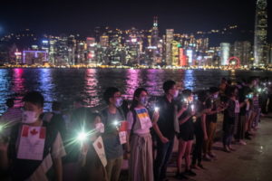 Protestujący trzymają się za ręce i świecą latarkami telefonów podczas „Hongkońskiego Szlaku” w Tsim Sha Tsui, Hongkong, 23.08.2019 r. Mieszkańcy Hongkongu utworzyli żywy łańcuch na rzecz demokracji (ROMAN PILIPEY/PAP/EPA)