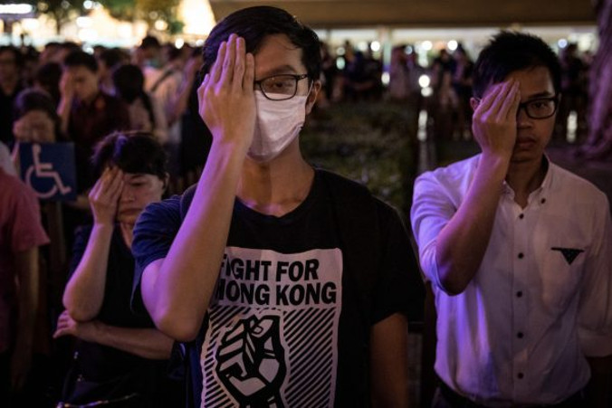 Protestujący zakrywają prawe oko i stoją w ciszy w 74. rocznicę wyzwolenia w Hongkongu, 30.08.2019 r. (Chris McGrath / Getty Images)