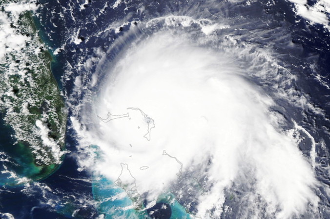 Zdjęcie satelitarne udostępnione przez NASA pokazuje huragan Dorian w naturalnych barwach o 14.05 wschodniego czasu letniego, 18.05 czasu uniwersalnego, 1.09.2019 r., wydane 2.09.2019 r. Potężny huragan Dorian 5 kategorii, z utrzymującymi się wiatrami o prędkości ok. 295 km/h, widoczny jest na zdjęciu bezpośrednio nad wyspą Wielkie Abaco, na północy Bahamów, po lewej stronie widać Florydę, Stany Zjednoczone (NASA EARTH OBSERVATORY HANDOUT/PAP/EPA)
