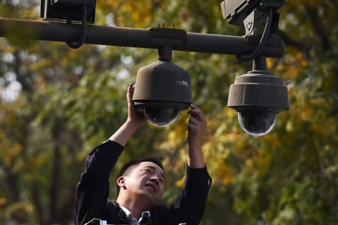 Pracownik reguluje kamery bezpieczeństwa na skraju pl. Tiananmen w Pekinie, 30.09.2014 r. (GREG BAKER/AFP/Getty Images)