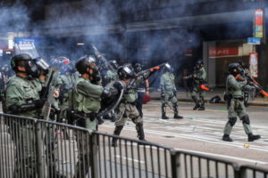 Policja wystrzeliwuje pojemniki z gazem łzawiącym w kierunku protestujących w 70. rocznicę proklamowania komunistycznej ChRL, Hongkong, 1.10.2019 r. (VIVEK PRAKASH/PAP/EPA)