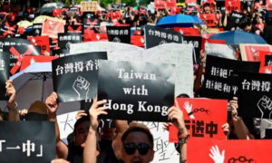 Manifestanci trzymają plakaty podczas demonstracji, aby wesprzeć protestujących w Hongkongu, Tajpej, 16.06.2019 r. (Sam Yeh/AFP/Getty Images)