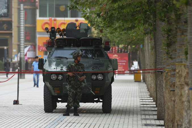 Niedatowane zdjęcie przedstawia członka chińskiej policji paramilitarnej przed pojazdem opancerzonym w Hotan w chińskim regionie Sinciang (Greg Baker/AFP/Getty Images)